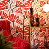 Roomset close-up of matisse pattern wallpaper in peach, chilli and seaweed green colourway 