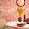 Roomset close-up of contemporary 70s, mehndi design wallpaper in hot pink and orange colourway 