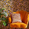 Pink and Ochre Leopard Skin Cushion on an Ochre Chair with a leopard print wallpaper